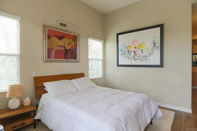 a bedroom with bed and wall painting with wooden floor