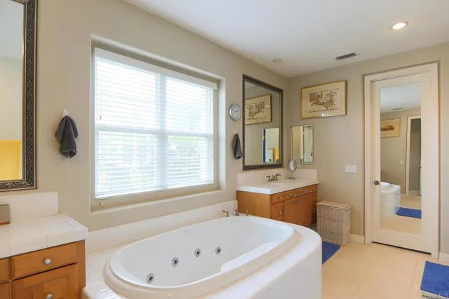 a bathroom with a tub sink and mirror