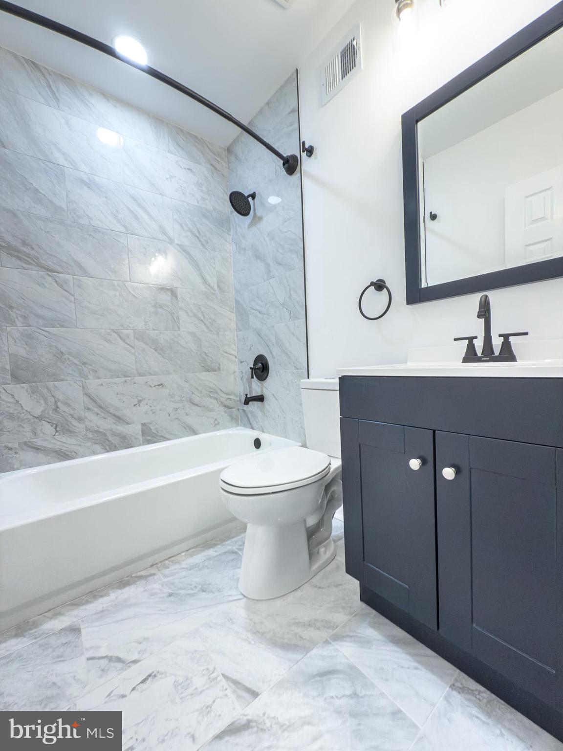 14909 Berry Road Accokeek, MD 20607 - Photo 20 of 32 a bathroom with a bathtub shower sink mirror and toilet