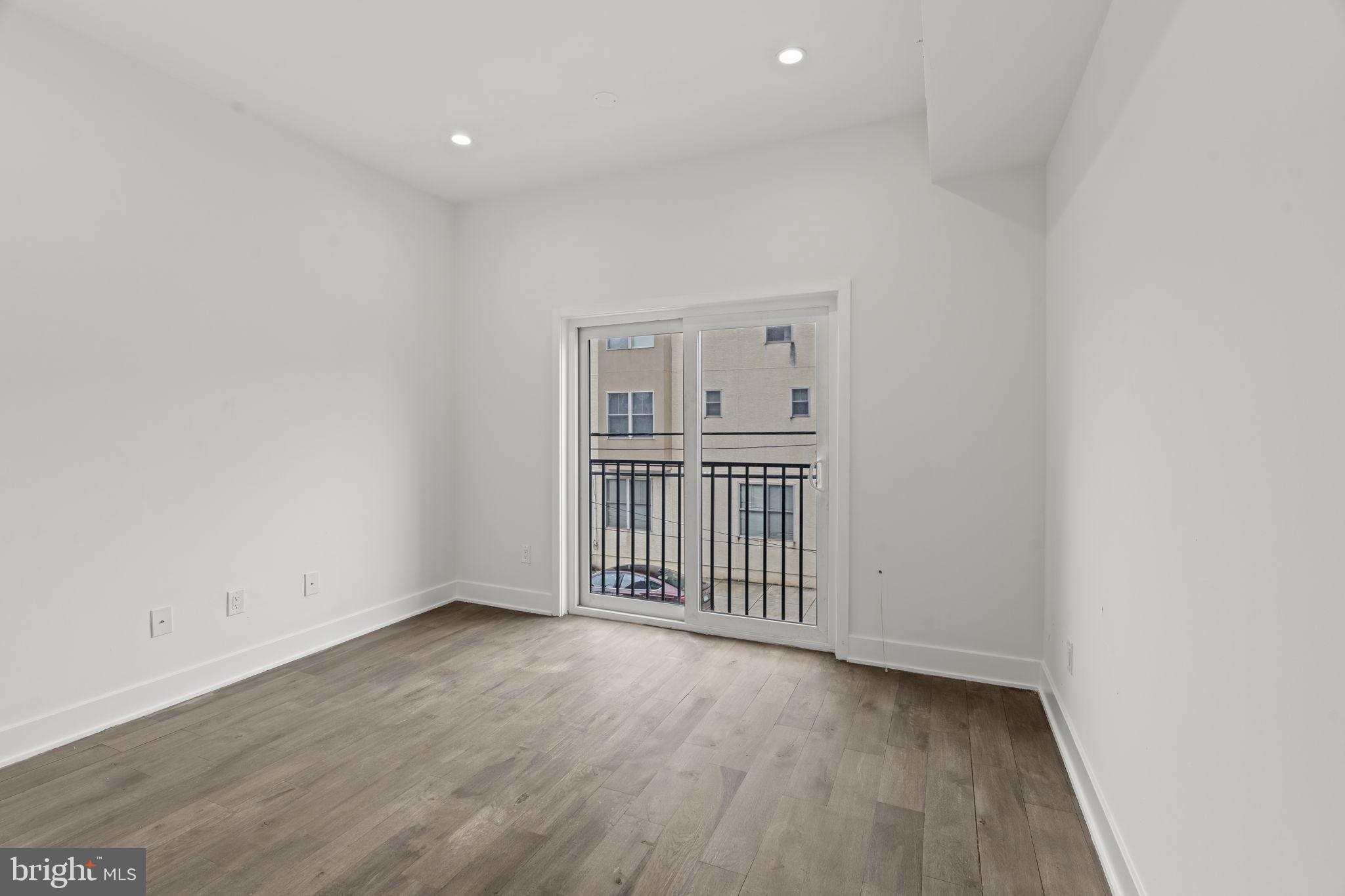 1244 South 20th Street, Unit 2 Philadelphia, PA 19146 - Photo 24 of 30 an empty room with wooden floor and windows