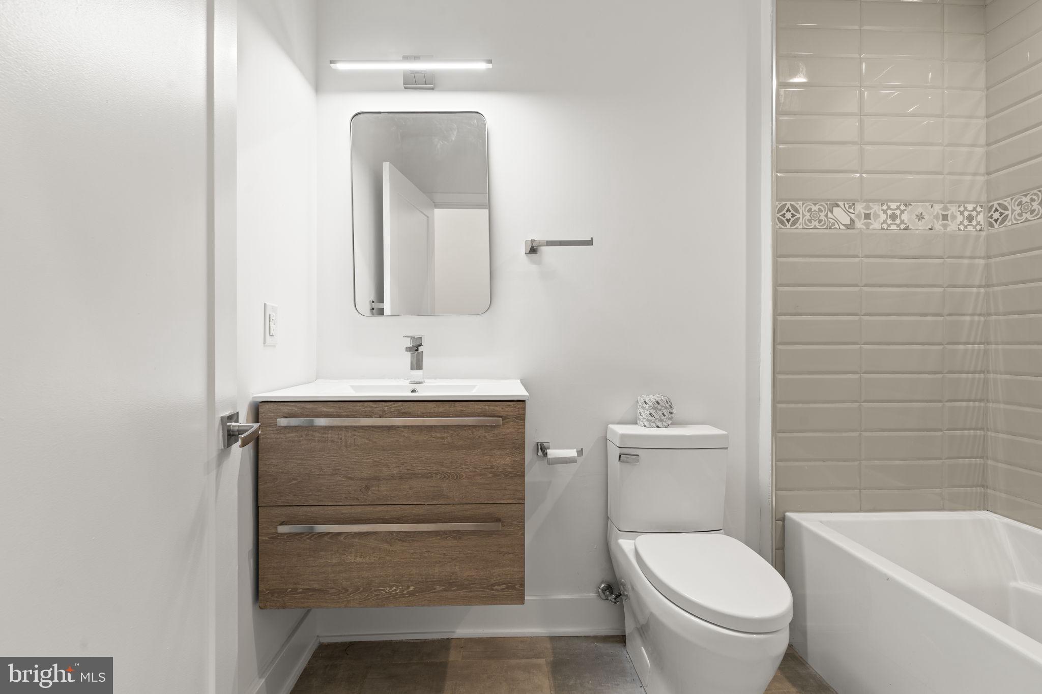1244 South 20th Street, Unit 2 Philadelphia, PA 19146 - Photo 26 of 30 a bathroom with a granite countertop toilet sink and mirror