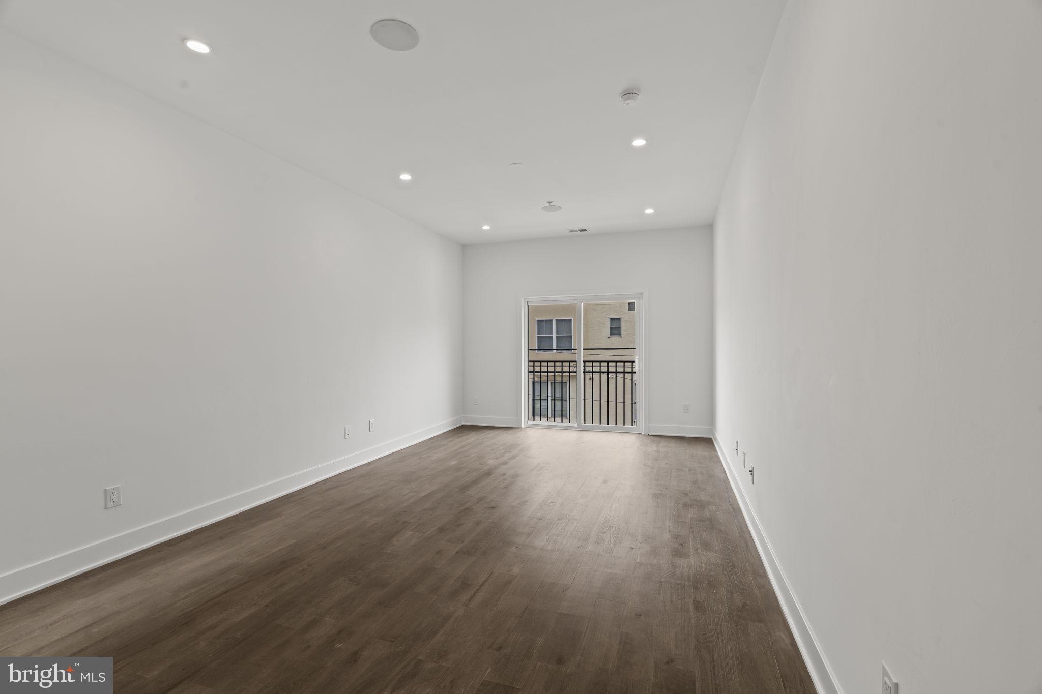 1244 South 20th Street, Unit 2 Philadelphia, PA 19146 - Photo 3 of 30 an empty room with wooden floor and windows