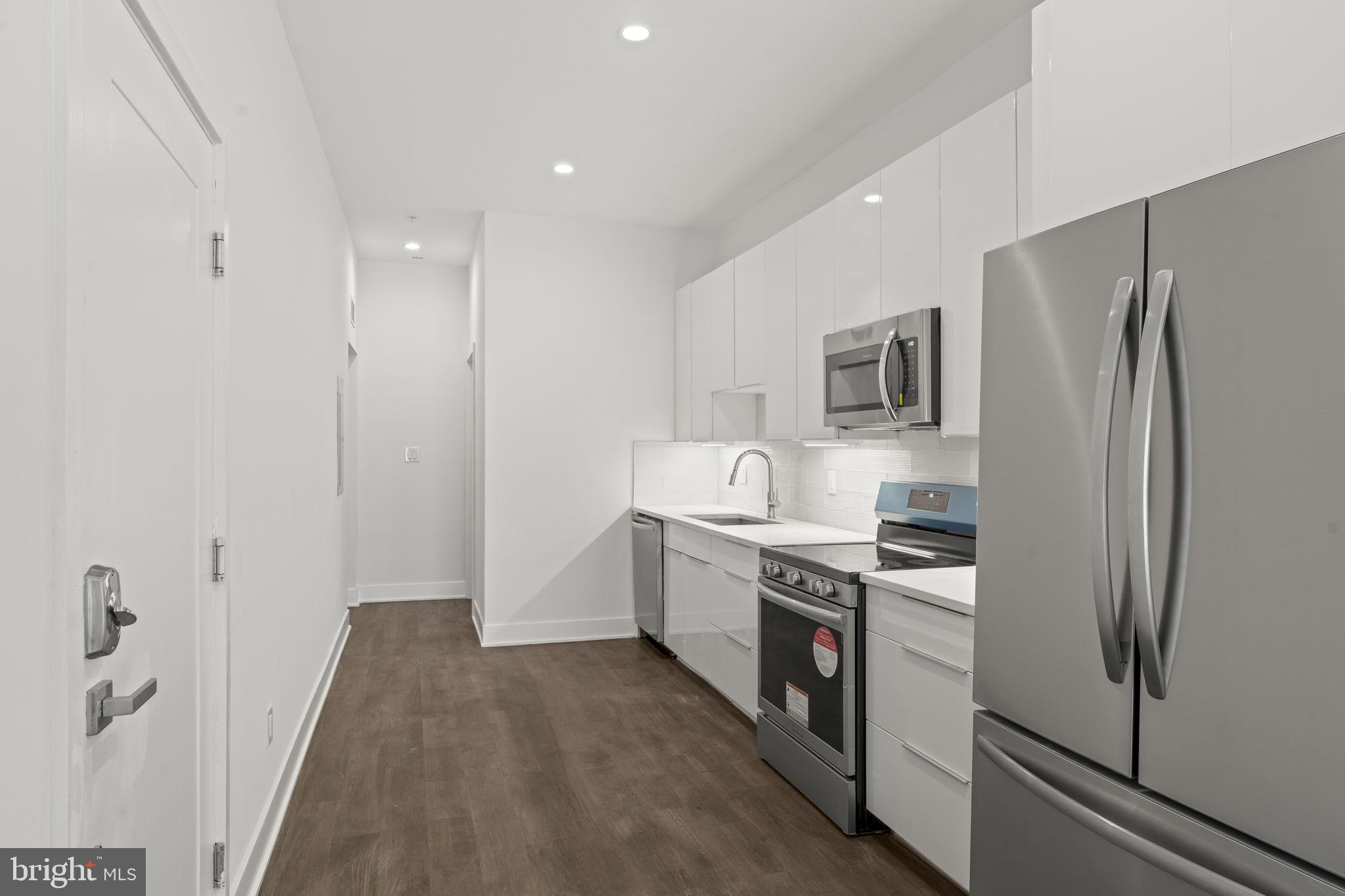 1244 South 20th Street, Unit 2 Philadelphia, PA 19146 - Photo 9 of 30 a kitchen with stainless steel appliances a refrigerator stove and sink