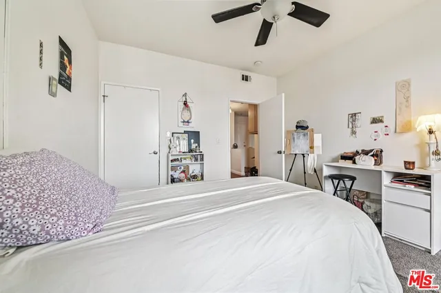 a spacious bedroom with a bed and a dresser in it