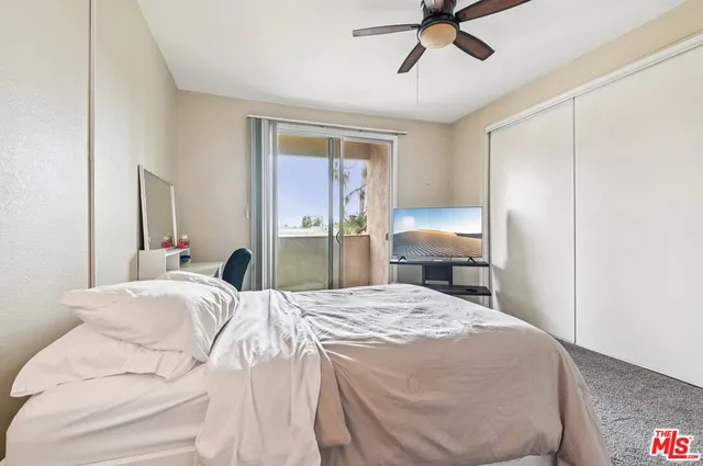 a bedroom with a bed and dresser with wooden floor