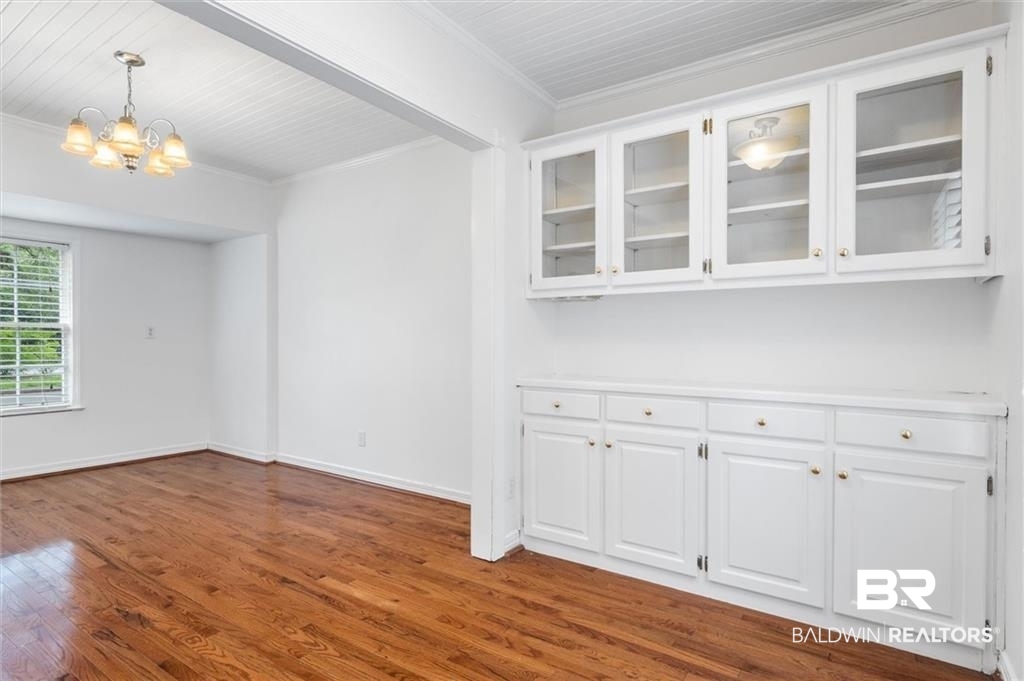 218 Grand Boulevard Mobile, AL 36607 - Photo 15 of 22 Unfurnished dining area featuring hardwood / wood-style flooring, a notable chandelier, and crown molding