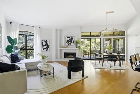 a living room with furniture a fireplace and a floor to ceiling window