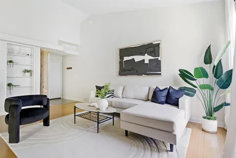 a living room with furniture and a potted plant