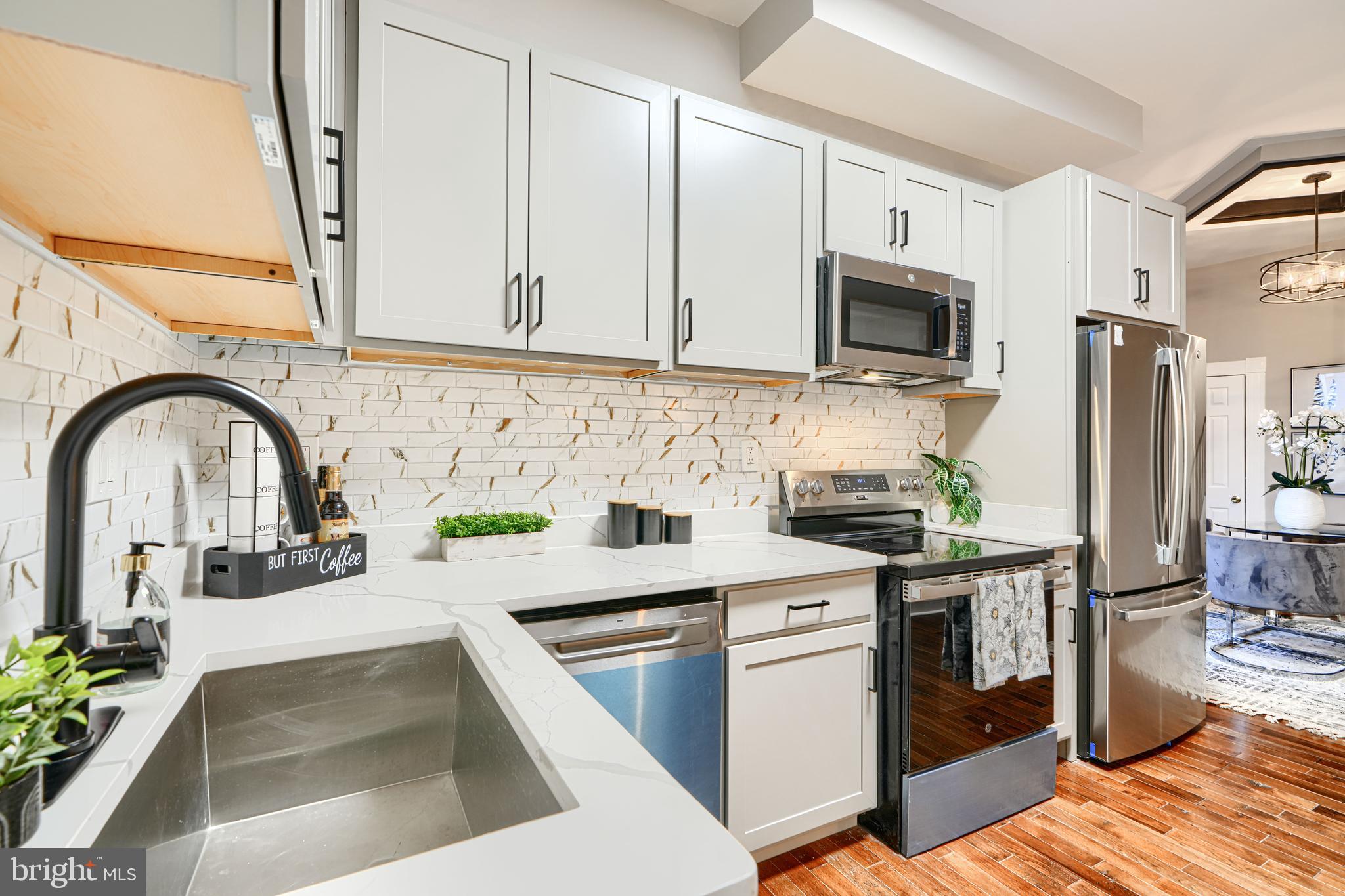717 East Biddle Street Baltimore, MD 21202 - Photo 22 of 47 a kitchen with stainless steel appliances a stove a sink a microwave and cabinets