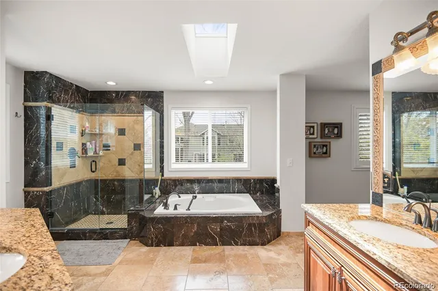 a spacious bathroom with a tub sink and mirror