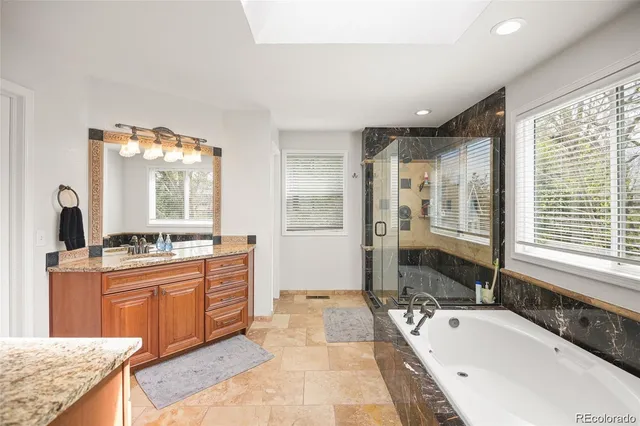 a spacious bathroom with a granite countertop tub sink and mirror