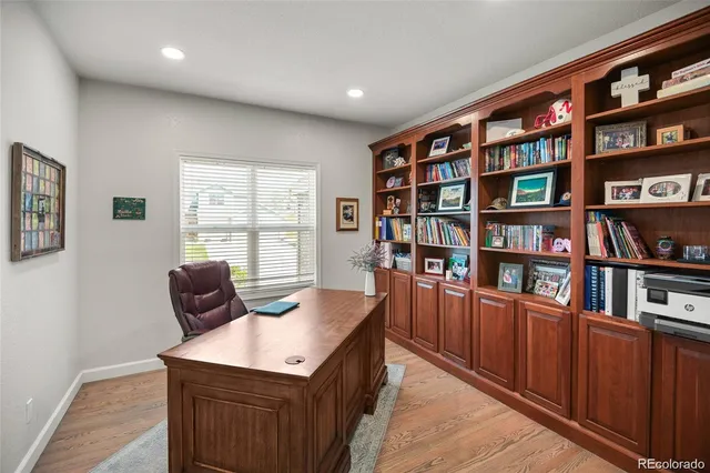 a view of a workspace with furniture and a book shelf