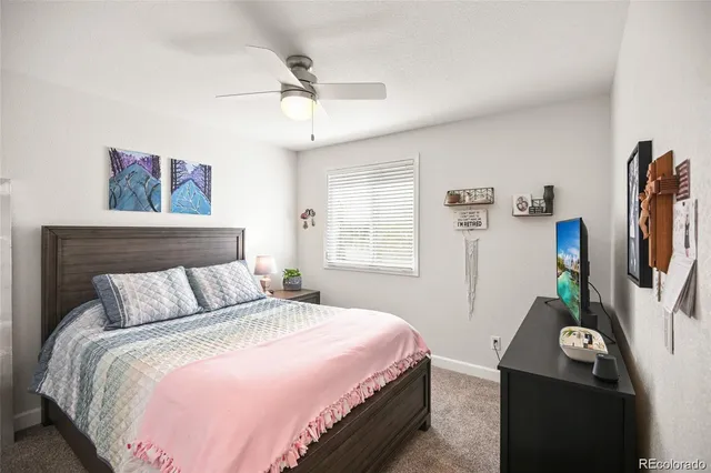 a bedroom with a bed and a flat tv screen on the dresser
