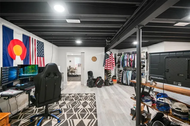 a living room with furniture a flat screen tv and gym equipment