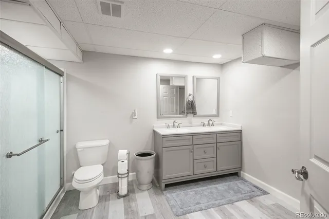 a bathroom with a granite countertop toilet sink and mirror