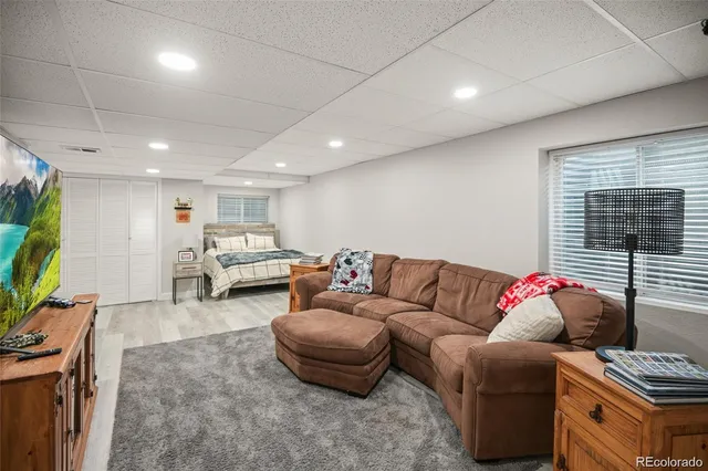 a living room with furniture a flat screen tv and a window