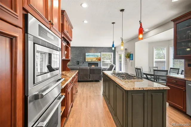a kitchen with granite countertop stove sink and refrigerator