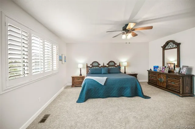 a bedroom with a bed window and mirror