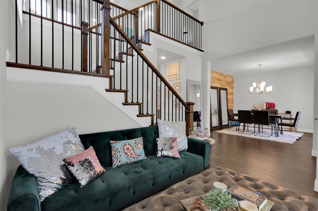 a living room with couches and a dining table with wooden floor