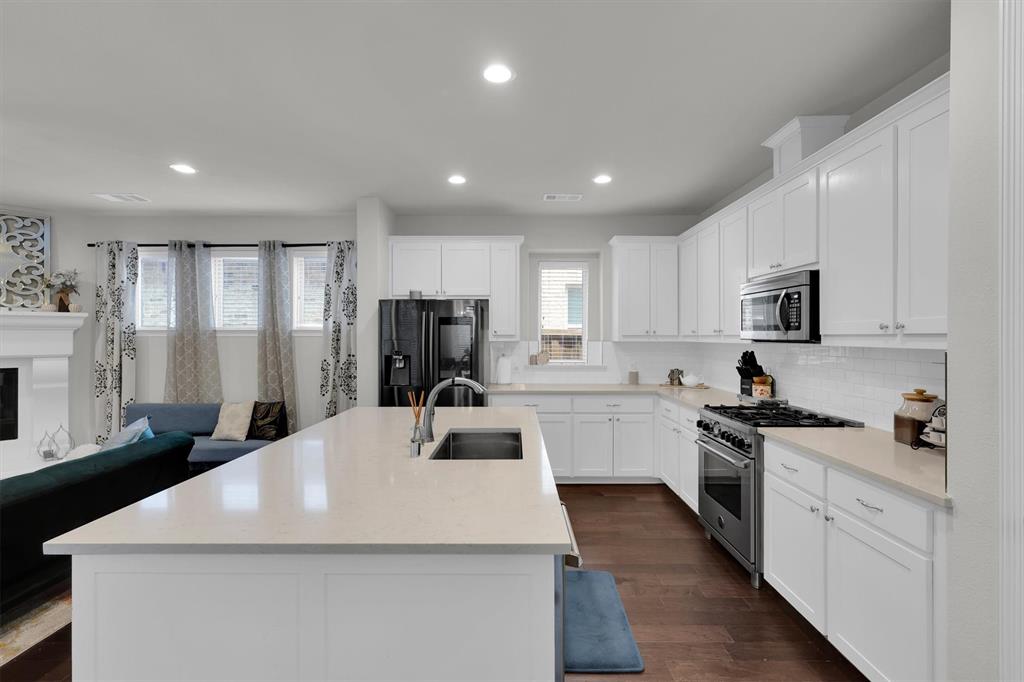 4504 Del Rey Avenue McKinney, TX 75070 - Photo 10 of 40 a kitchen with sink a refrigerator and white cabinets