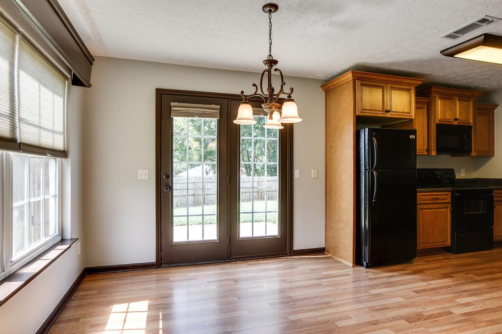 1909 Portway Road Spring Hill, TN 37174 - Photo 12 of 30 a view of a room with wooden floor chandeliers and kitchen view