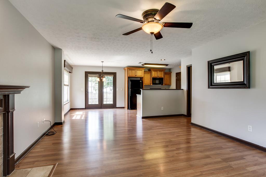 1909 Portway Road Spring Hill, TN 37174 - Photo 7 of 30 a view of a livingroom with a ceiling fan a kitchen wooden floor and a ceiling fan