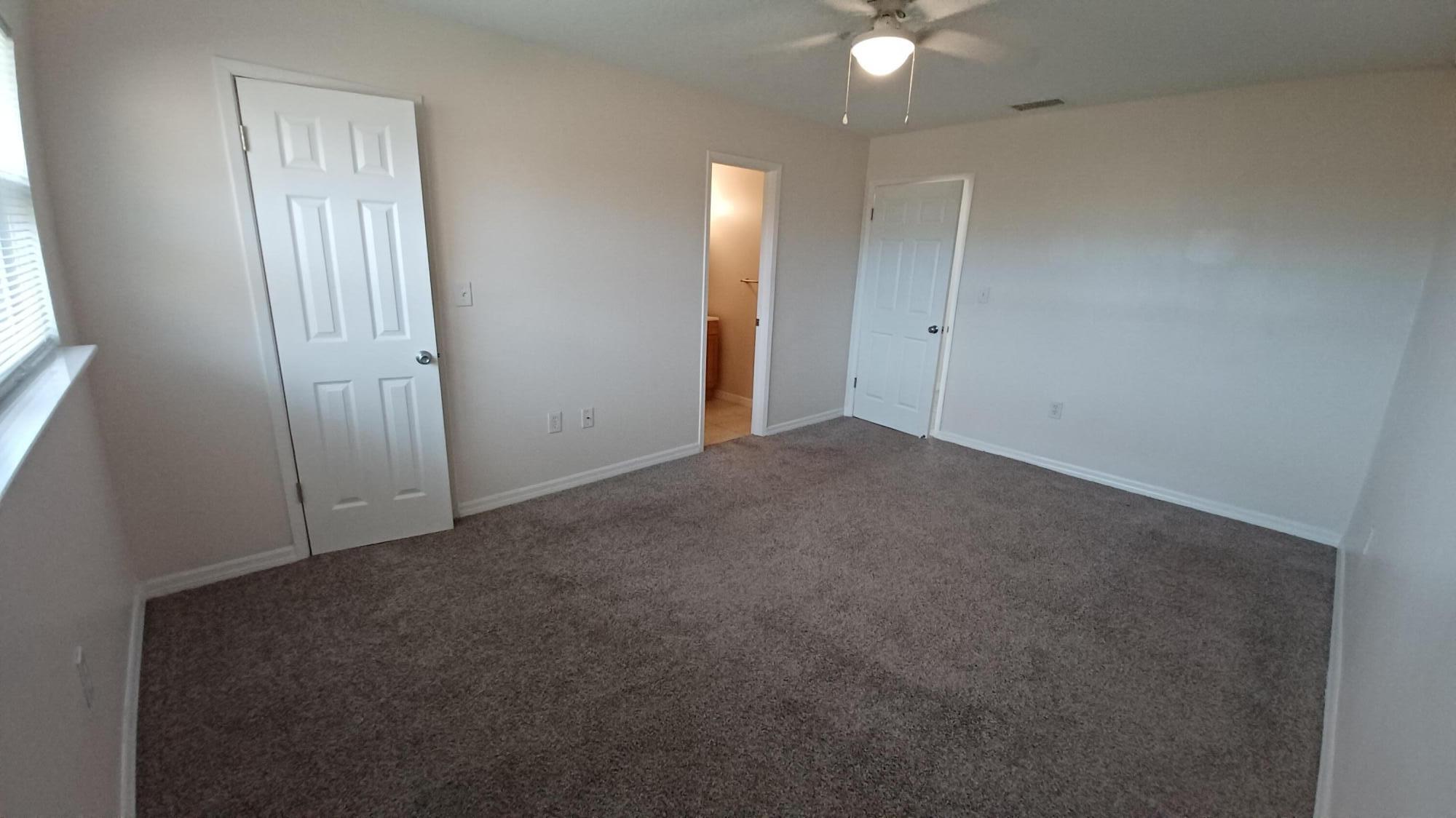 280 Ulster Lane Melbourne, FL 32935 - Photo 16 of 34 an empty room with closet and a chandelier fan