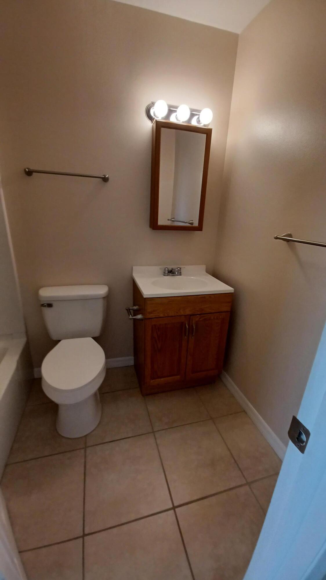 280 Ulster Lane Melbourne, FL 32935 - Photo 18 of 34 a bathroom with a toilet a sink and mirror