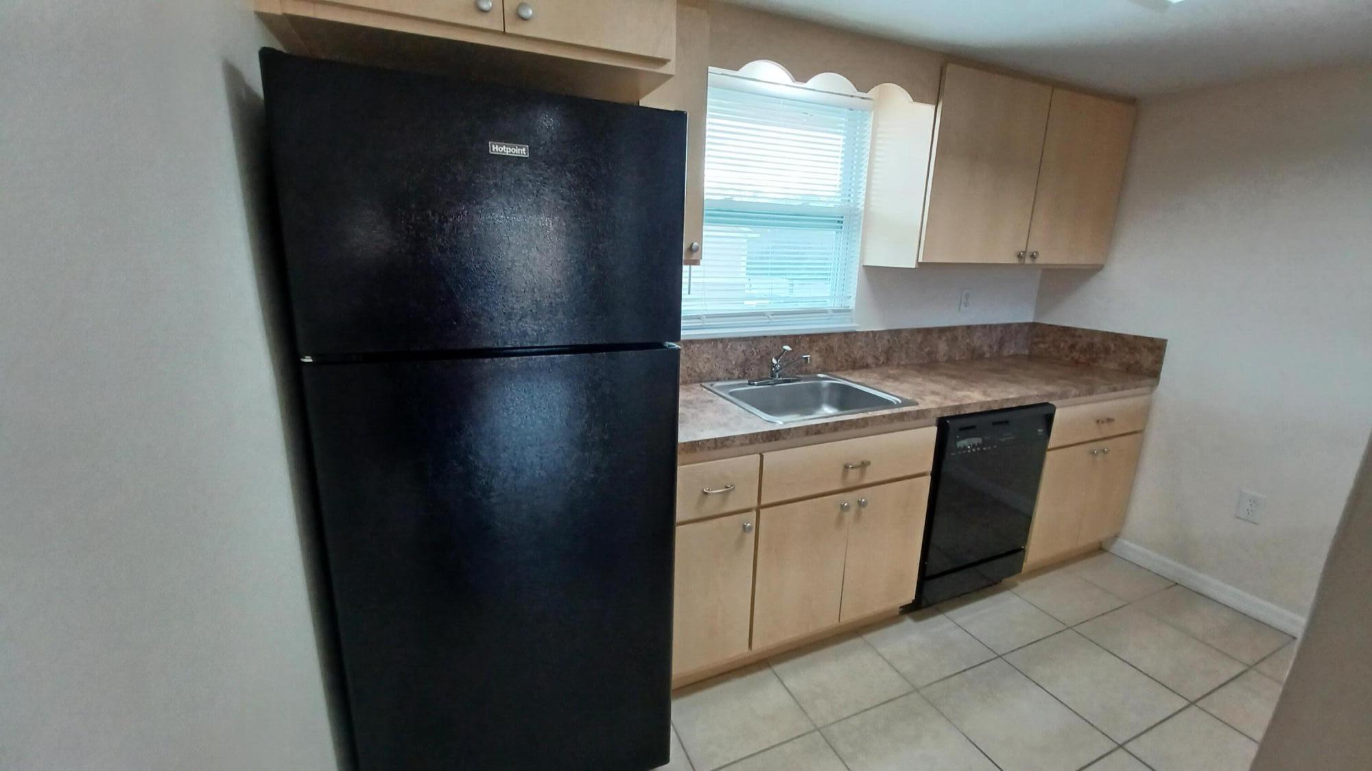 280 Ulster Lane Melbourne, FL 32935 - Photo 5 of 34 a kitchen with a refrigerator and cabinets