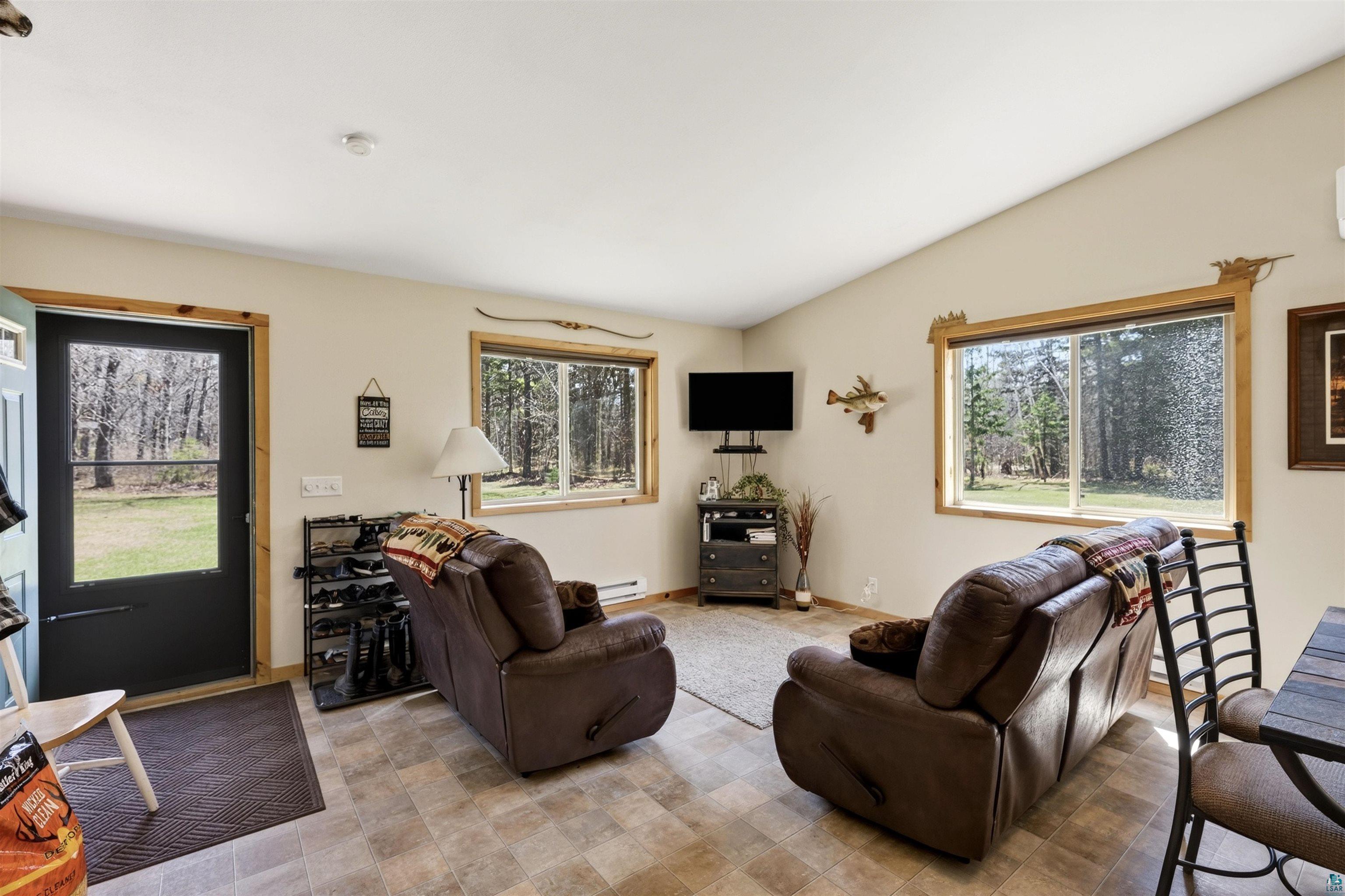 12235 East Crooked Lake Road Gordon, WI 54838 - Photo 9 of 48 Living area with vaulted ceilings, wood-finish window trim, and durable tile flooring