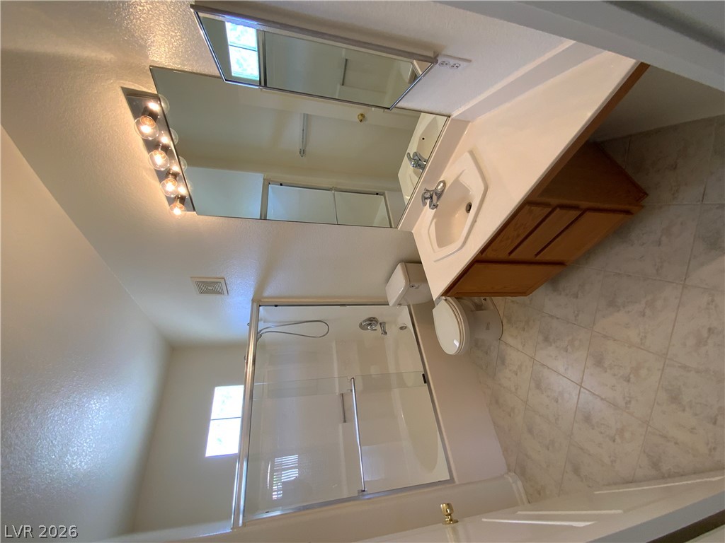 7400 West Flamingo Road, Unit 1039 Las Vegas, NV 89147 - Photo 11 of 40 A well-appointed bathroom features a single vanity, ample mirror space, and a glass-enclosed shower.