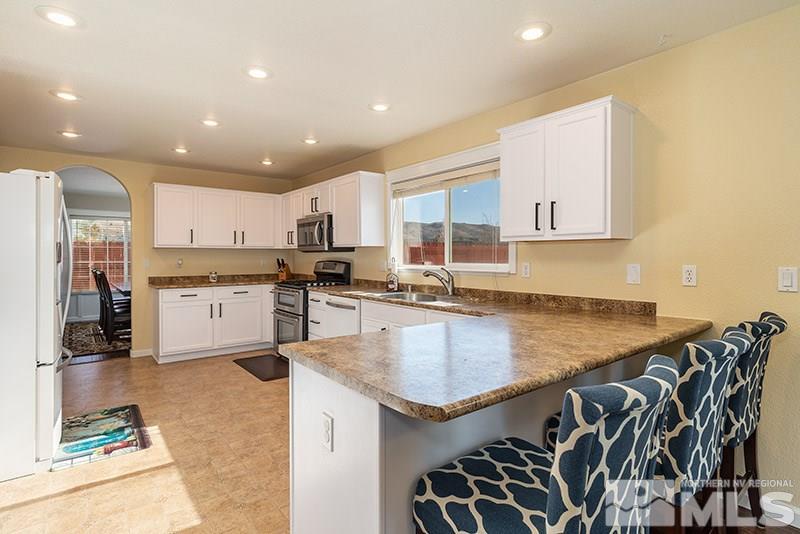 18366 Whitebark Court Reno, NV 89508 - Photo 21 of 36 a kitchen with stainless steel appliances granite countertop a sink and a stove