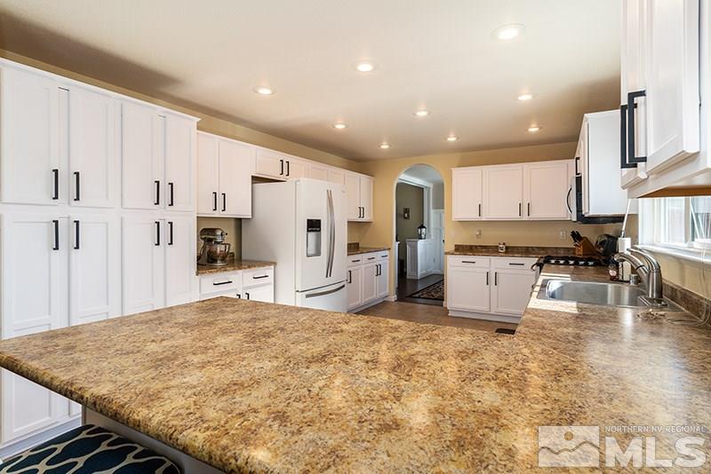 18366 Whitebark Court Reno, NV 89508 - Photo 22 of 36 a kitchen with stainless steel appliances kitchen island granite countertop a refrigerator and cabinets