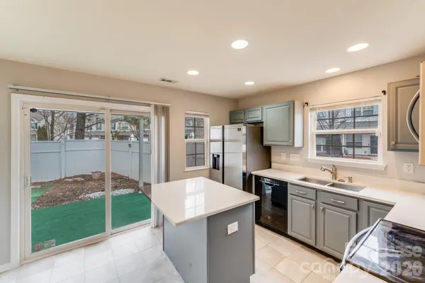 a kitchen with a sink and chairs