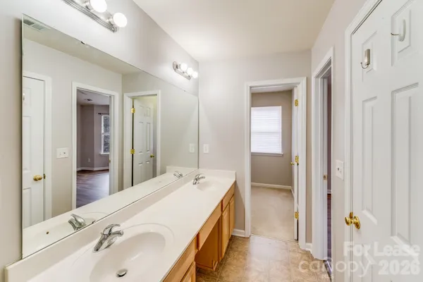 a spacious bathroom with a tub sink and mirror