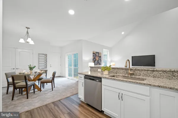 a dining hall with stainless steel appliances granite countertop a stove and a sink