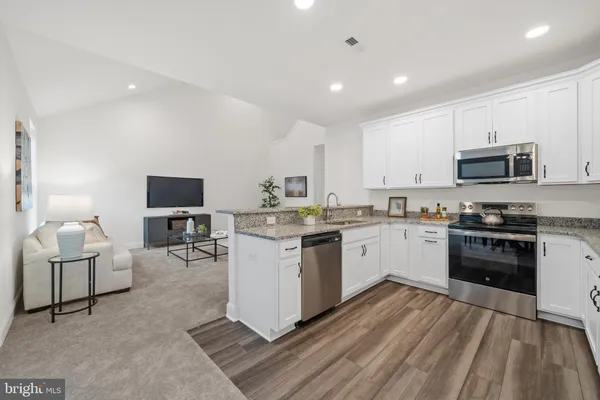 a kitchen with table chairs microwave and cabinets