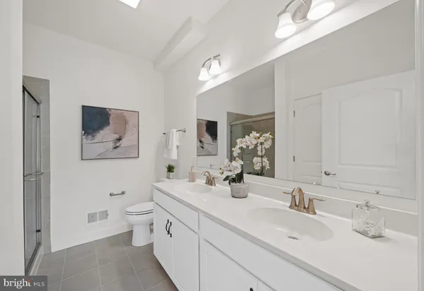 a bathroom with a double vanity sink mirror and toilet