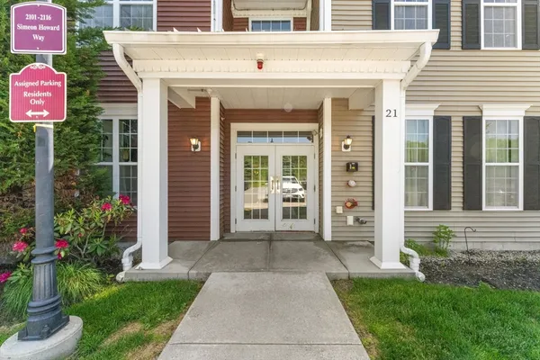 a front view of a house with a yard and potted plants