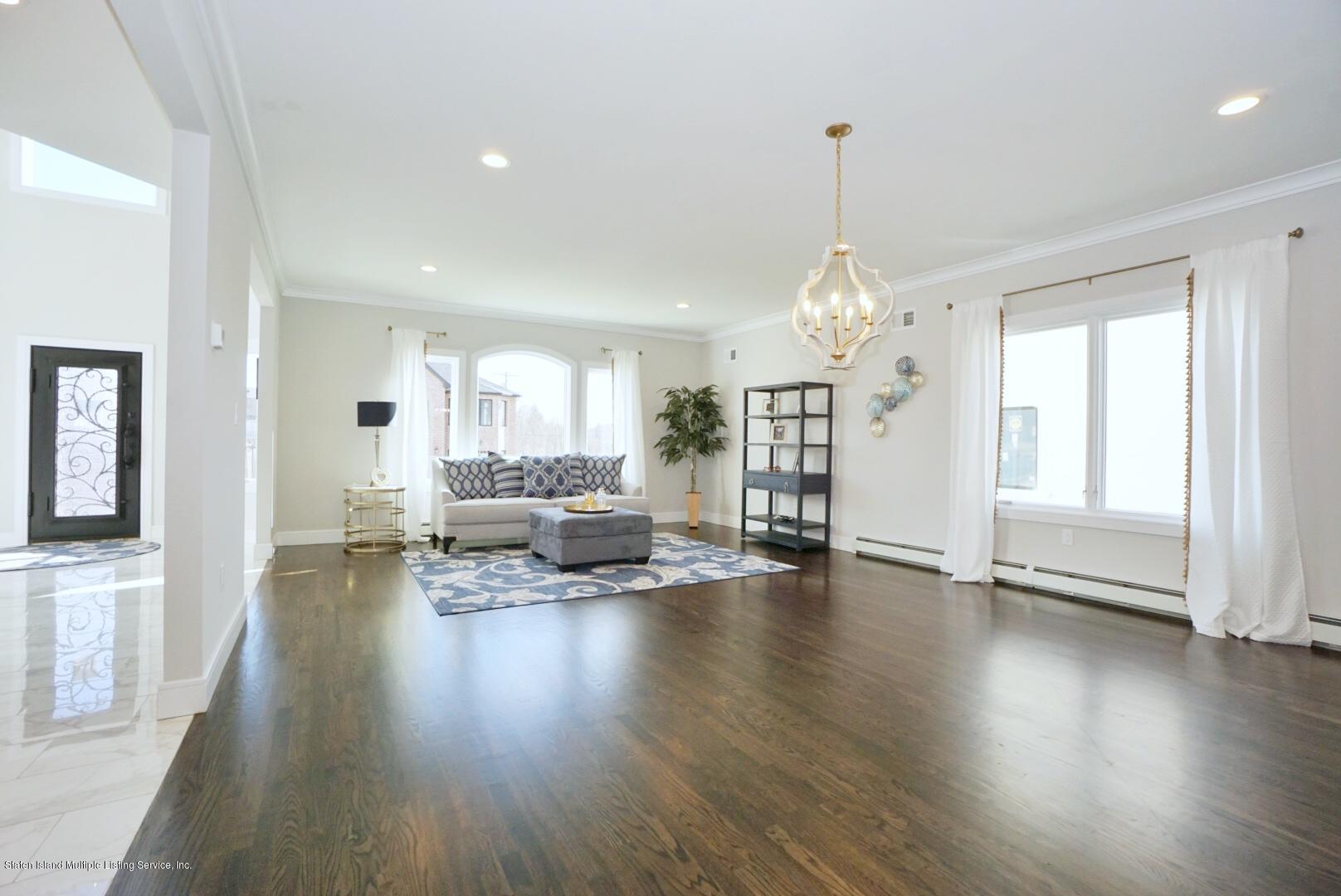 31 Torrice Loop Staten Island, NY 10309 - Photo 15 of 69 a view of a livingroom with furniture wooden floor windows and a chandelier