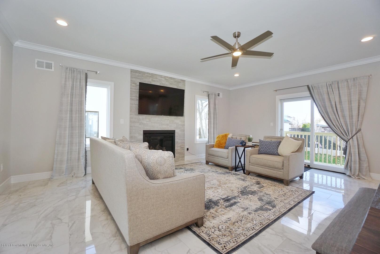 31 Torrice Loop Staten Island, NY 10309 - Photo 19 of 69 a living room with furniture a fireplace and a flat screen tv