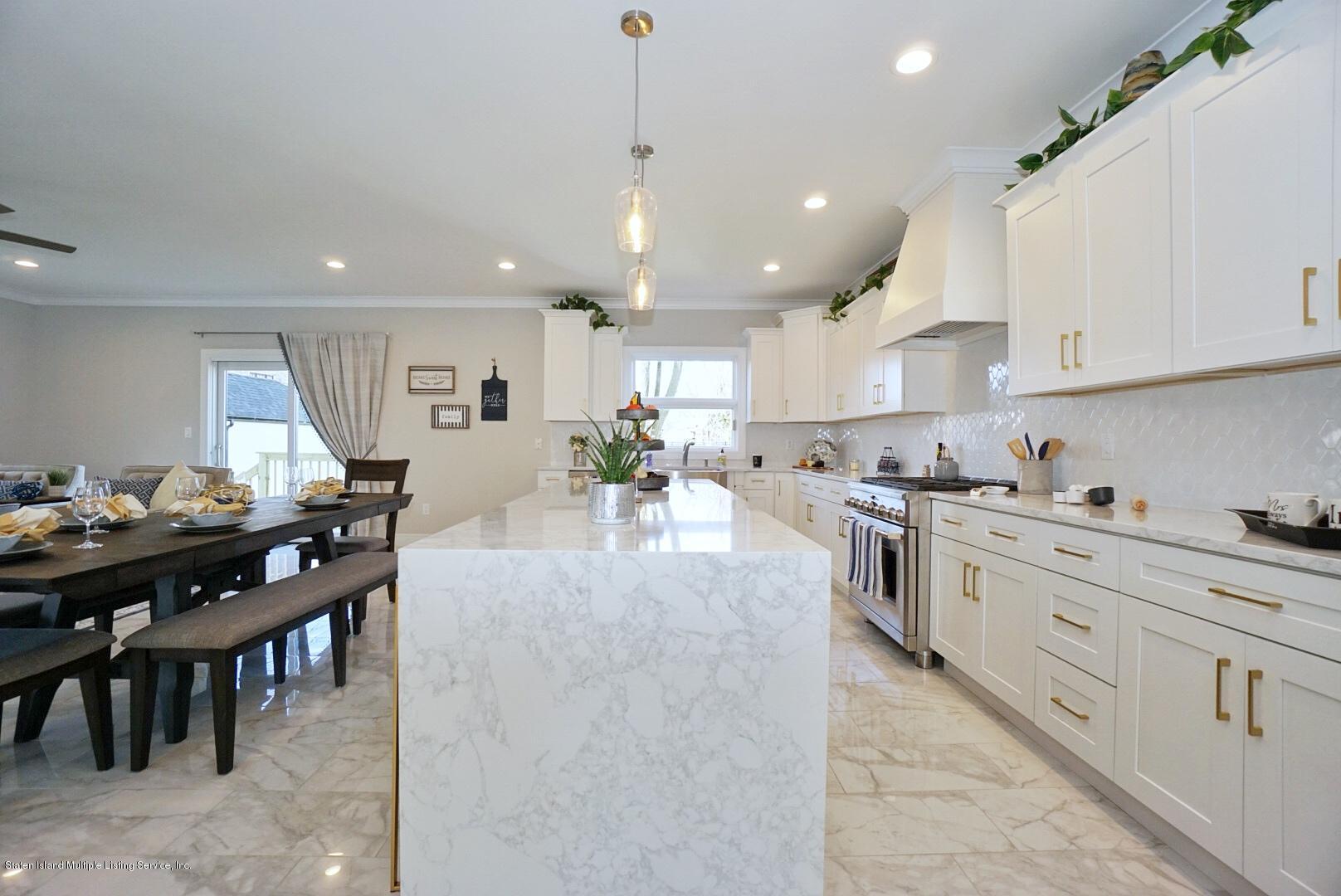 31 Torrice Loop Staten Island, NY 10309 - Photo 26 of 69 a large white kitchen with lots of counter space a sink dining table and chairs