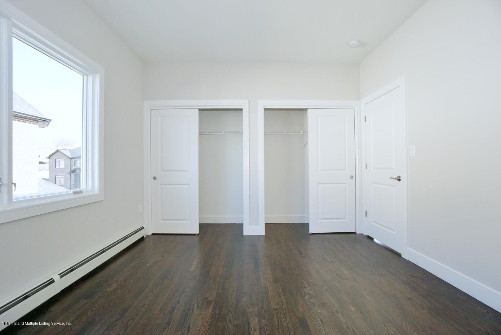 31 Torrice Loop Staten Island, NY 10309 - Photo 38 of 69 an empty room with wooden floor and windows