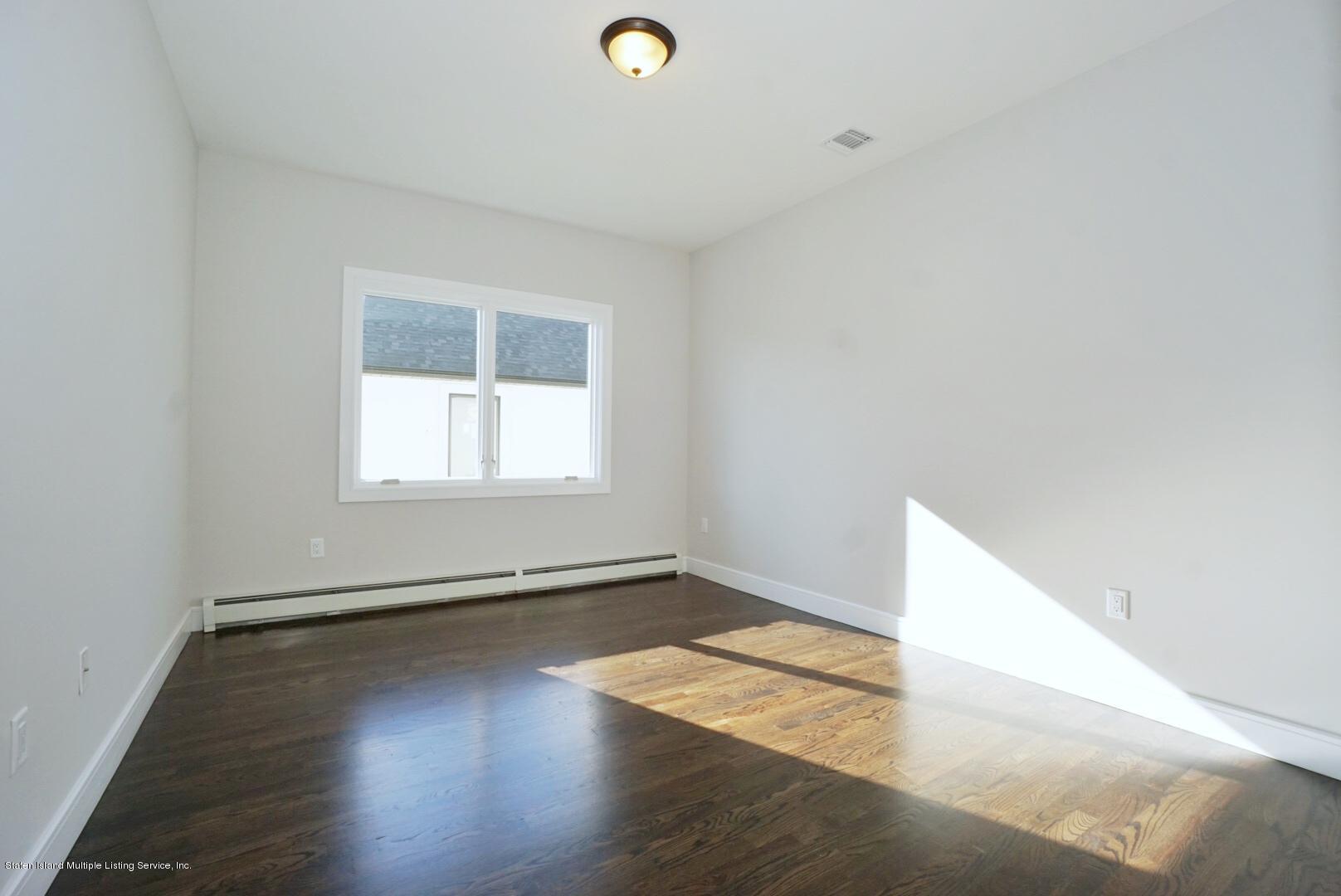31 Torrice Loop Staten Island, NY 10309 - Photo 39 of 69 an empty room with wooden floor and windows