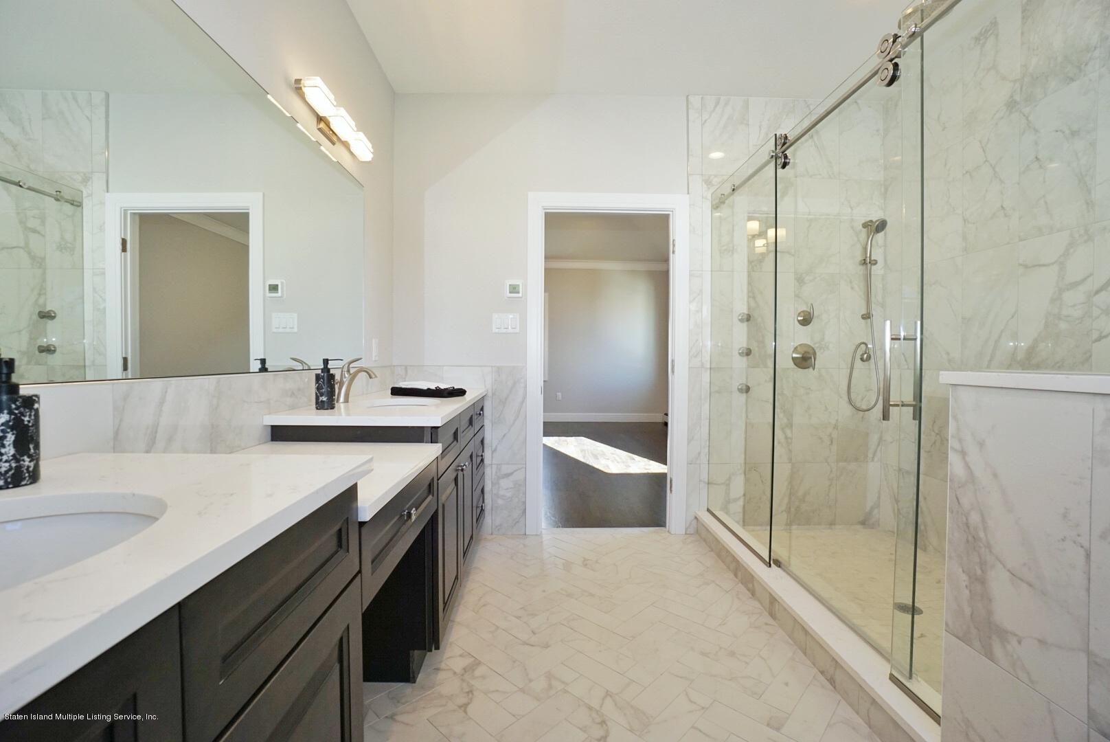 31 Torrice Loop Staten Island, NY 10309 - Photo 50 of 69 a bathroom with a granite countertop sink a toilet a mirror and shower