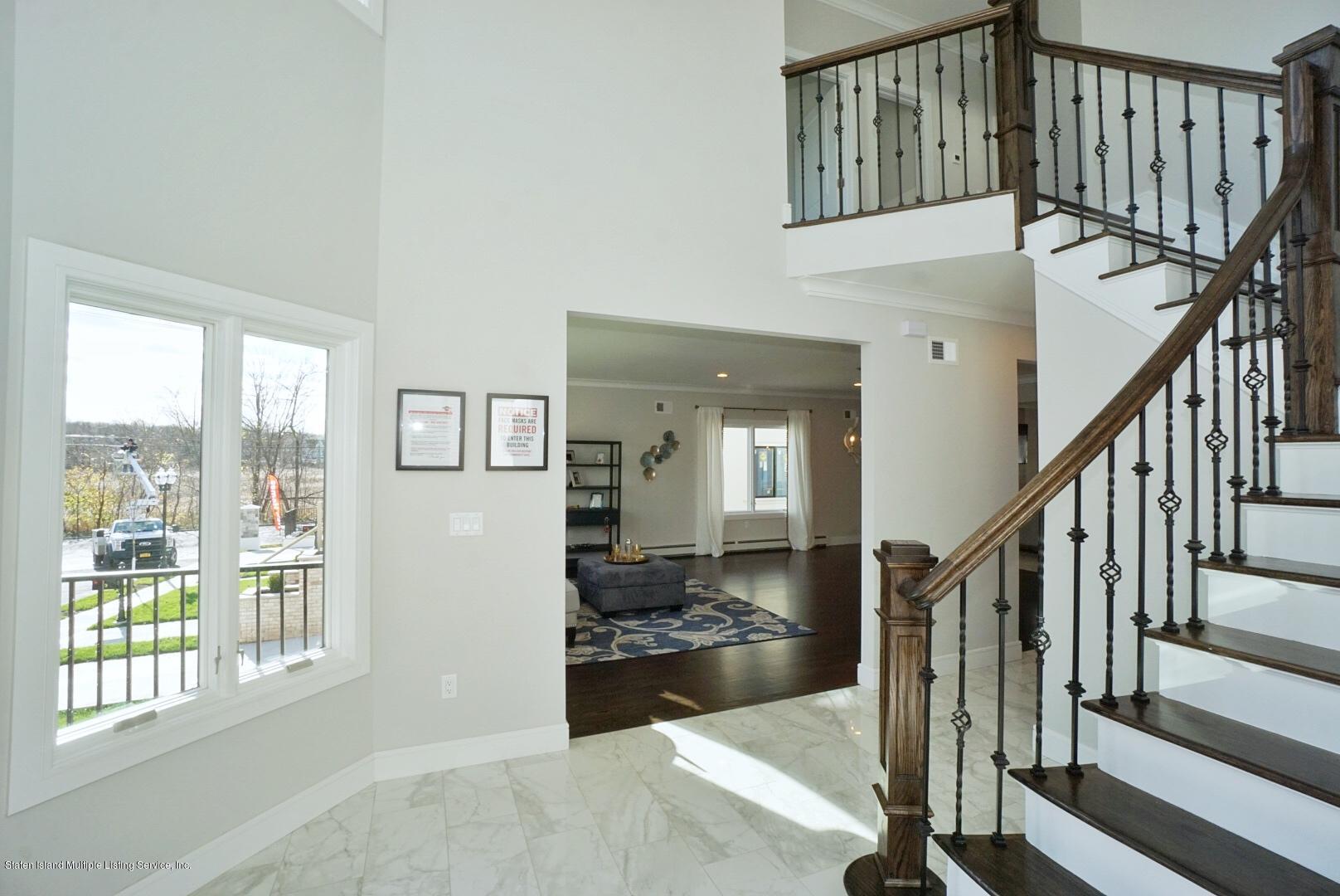31 Torrice Loop Staten Island, NY 10309 - Photo 6 of 69 a view of an entryway with wooden floor leading to a furnished livingroom and windows