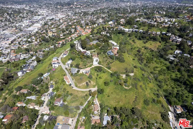 an aerial view of a residential houses with city view