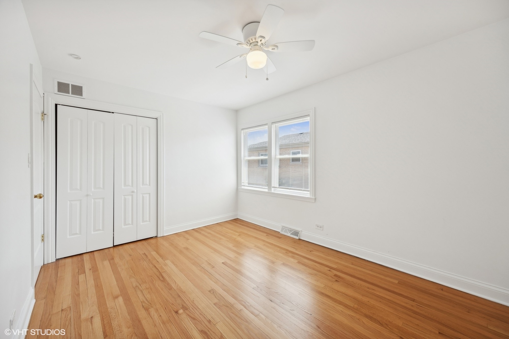 8152 Mayfield Avenue Burbank, IL 60459 - Photo 13 of 27 a view of empty room with wooden floor and fan