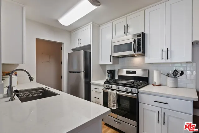 a kitchen with cabinets and stainless steel appliances