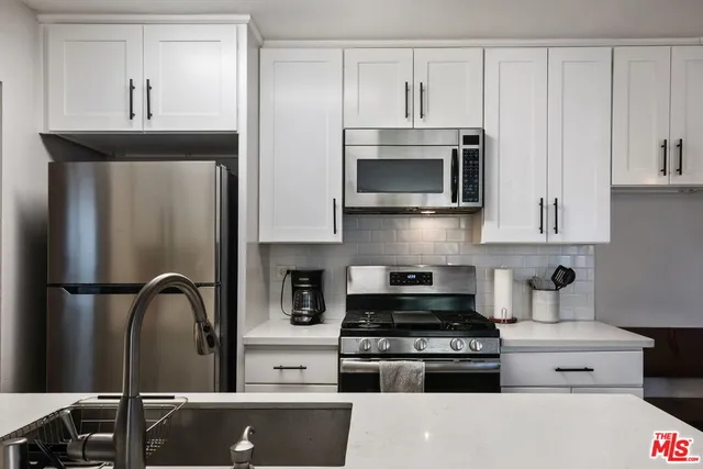 a kitchen with a stove a sink and a microwave